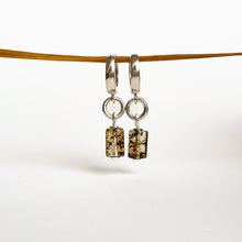 Load image into Gallery viewer, A pair of silver 925 earrings with natural polished Baltic Amber attached to round hoops, displayed against a white background.