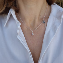 Load image into Gallery viewer, A woman wearing a white shirt is adorned with a silver pendant necklace featuring a moonstone gemstone, with the necklace clasp visible at the top of the image.