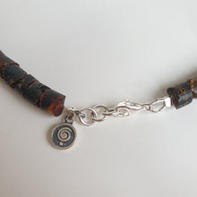 Load image into Gallery viewer, Bracelet with wooden beads and a silver spiral charm on a light gray background