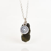 Load image into Gallery viewer, A silver chain necklace featuring a circular silver pendant with a spiral design, attached to a dark, rough, textured stone charm, shown against a plain white background.