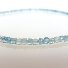 Load image into Gallery viewer, Close-up of a string of light blue aquamarine faceted beads on a white background