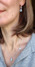 Load image into Gallery viewer, Close-up of a person wearing silver earrings and a necklace with opal stones.