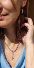 Load image into Gallery viewer, Close-up of a woman wearing silver earrings and a necklace, with a blurred background.