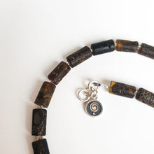 Load image into Gallery viewer, Beaded bracelet with a silver charm on a white background